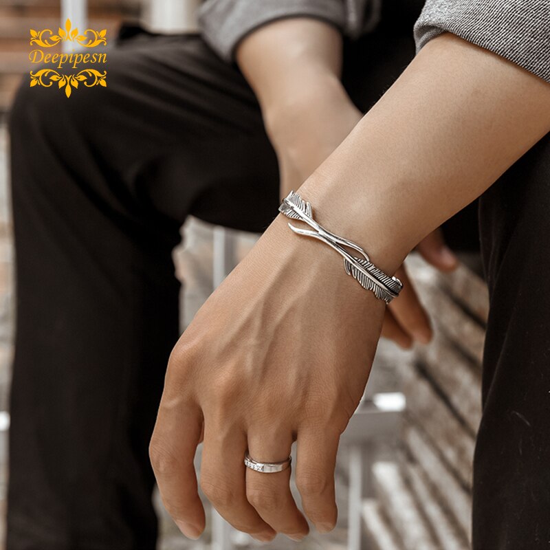 Silbernes retro-Armbinde mit federdesign für herren und jungen – ein trendiges schmuckaccessoire für freunde und Partner.