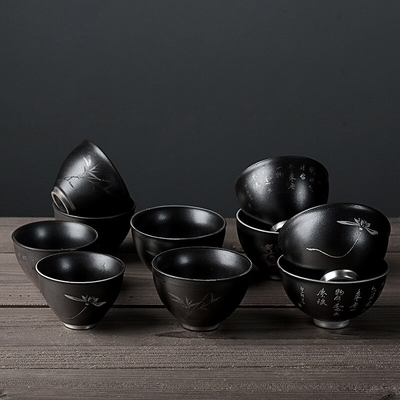 Beschrijving van een zwarte theekop van aardewerk, een zilveren retro theekopje, een zen theekopje, een middelgrote theeset met een kop en een pin-cha-bei.