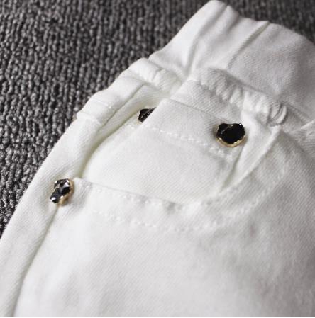 Jeans barnpojke vita avslappnade byxor i den stora pojken vår och höst smala fötter trasiga byxor bokstäver broderi