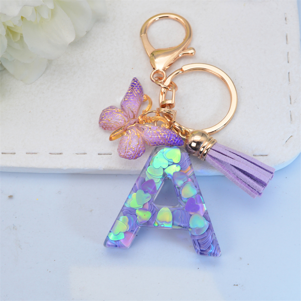Exquisito llavero de resina brillante azul con 26 iniciales, llavero con colgante de borla de mariposa púrpura con letra de A a Z para mujeres y hombres, para parejas: Blanco