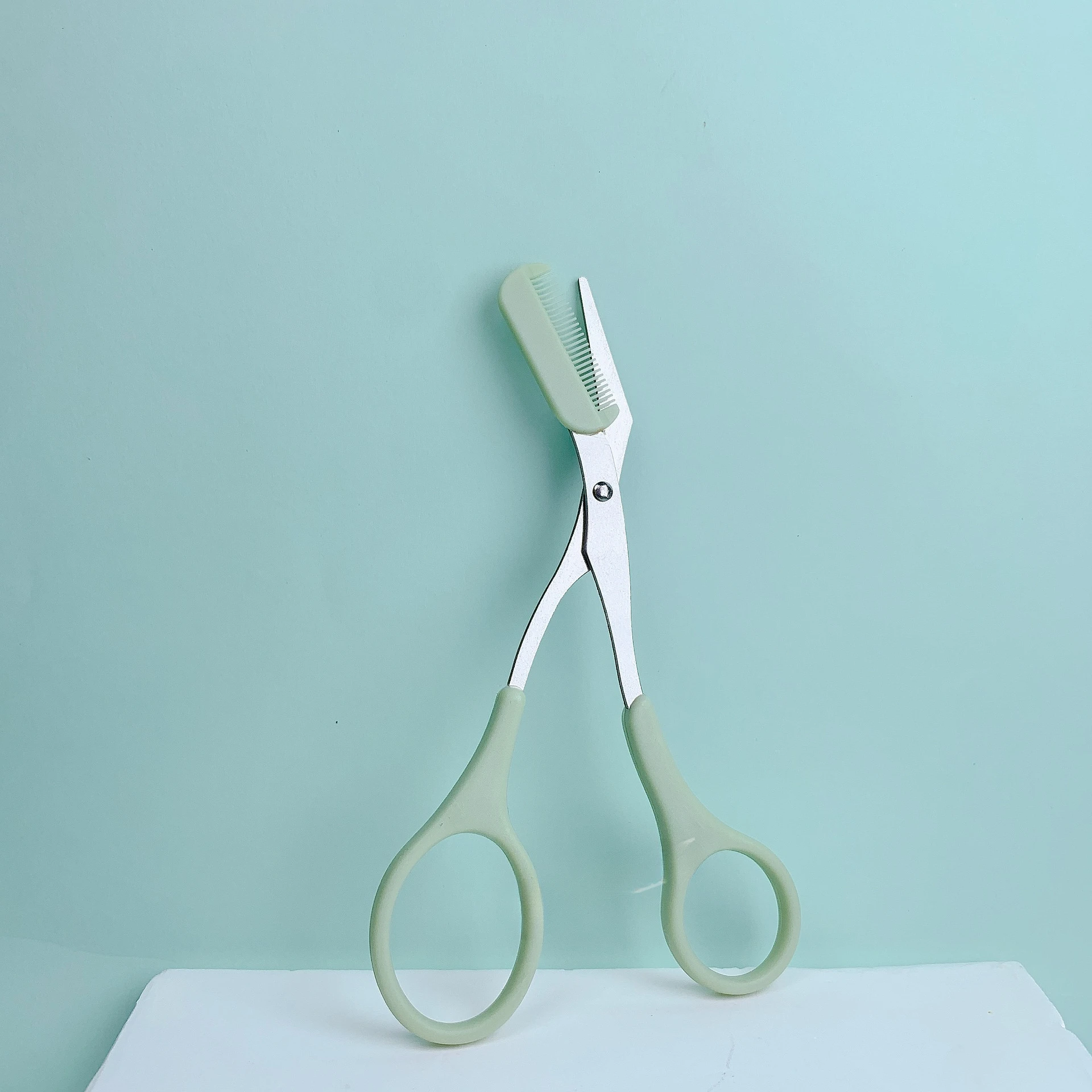 Pink eyebrow trimming scissors with built-in comb - stainless steel, precise grooming tool, creating perfect eyebrows: green