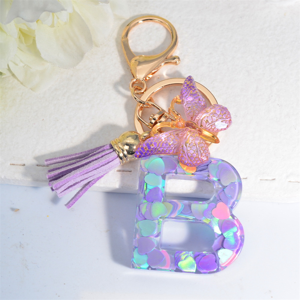 Exquisito llavero de resina brillante azul con 26 iniciales, llavero con colgante de borla de mariposa púrpura con letra de A a Z para mujeres y hombres, para parejas: Negro