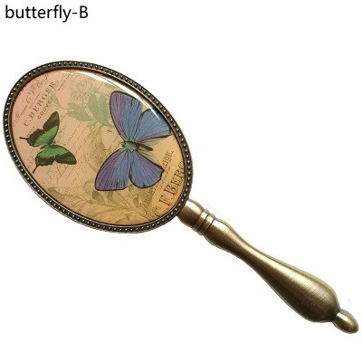 Europeisk vintage antik mässing oval 3 x 4 tum metalllegerad inramad glashandspegel med fjäril epoxidekor bak