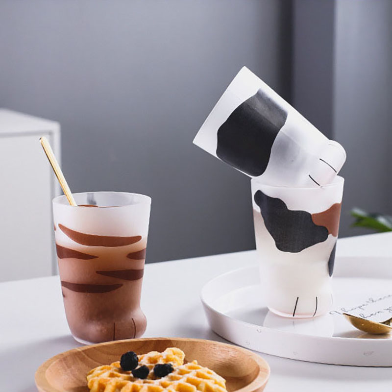 Søte katt poter tiger poter glass krus kopp gjennomsiktig kaffe te juice drikker dessert frokost melk spesielt
