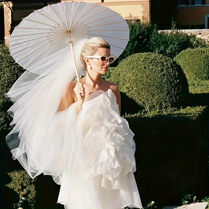 Un paraguas de papel blanco para decoración de bodas: sombrilla nupcial tradicional china hecha a mano, accesorio para fotografía y accesorio de