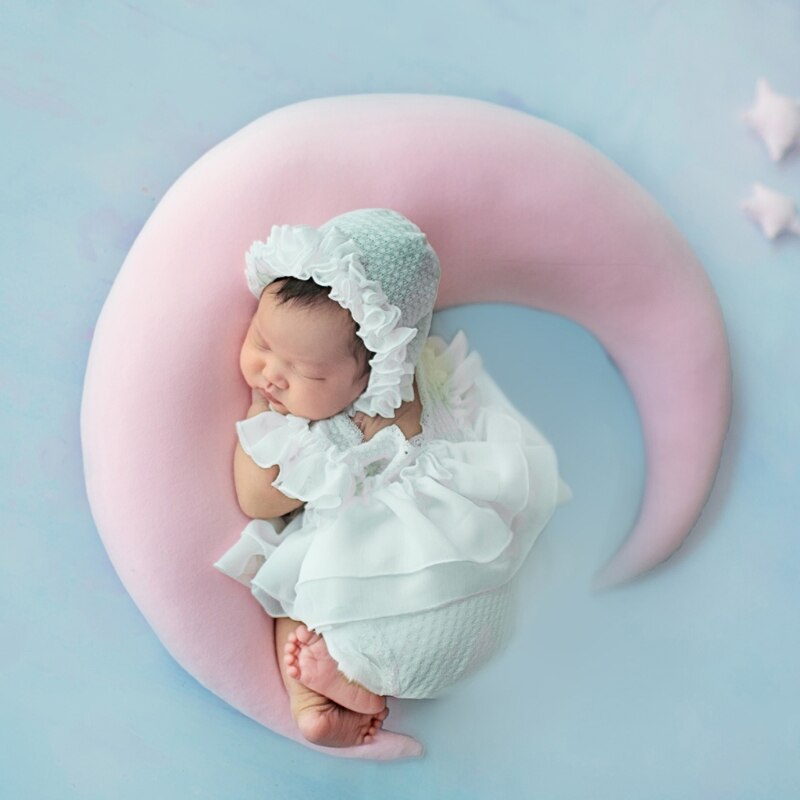 Set van 5 pasgeboren fotografie-accessoires: kanten jurkje, hoedje, kussentje, korte broek en schoenen.