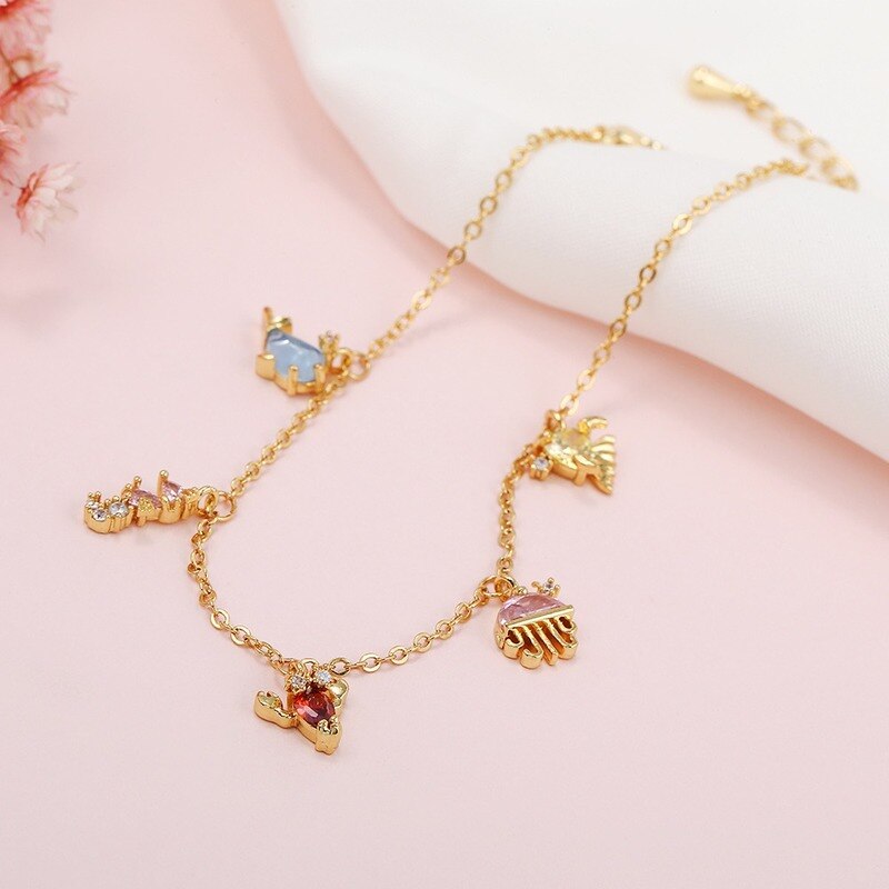 18k vergoldete fußkettchen mit exquisiten kleinen anhängern in form von meerestieren – schlichter, sommerlicher boho-schmuck für damen.