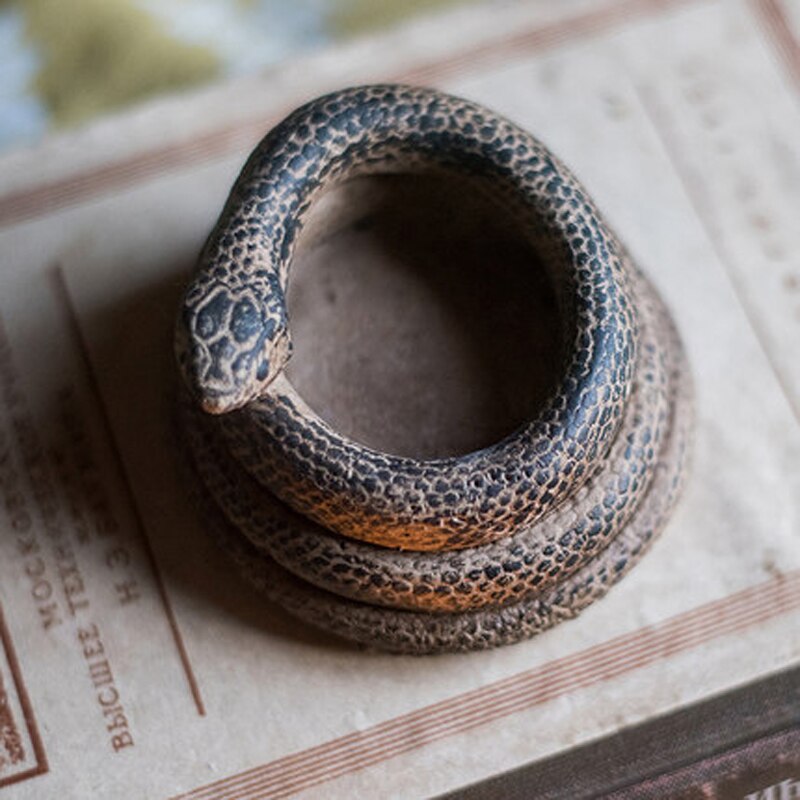 Decoratieve theelichthouders van beton in de vorm van een slang