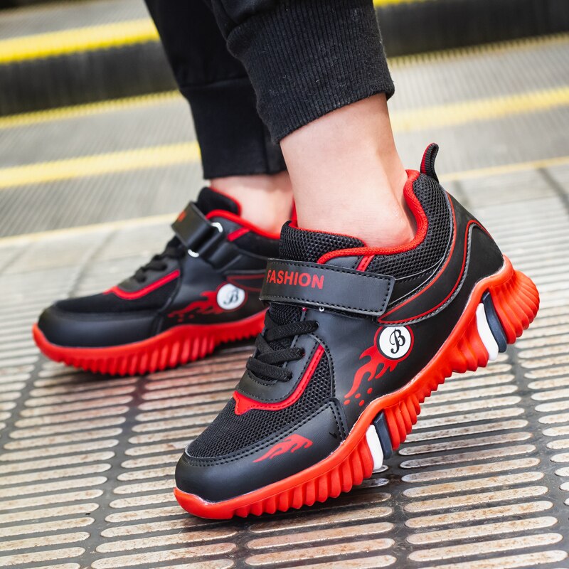 A child wearing black and red children's sneakers in a close-up lifestyle photo