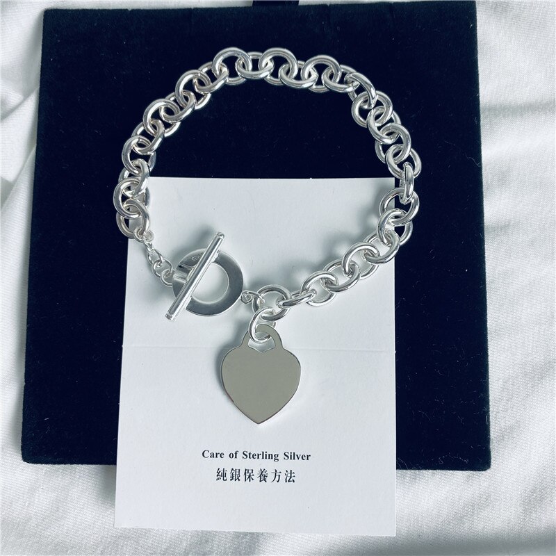 Klassisches silberarmband „argent 925 femme“ mit herzförmigem anhänger, origineller schmuck, hochwertiges herren- und damen-etikett.