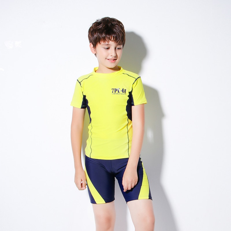 Teenagedrenge bærer to-delt badetøj børnetøjs sportstøj kortærmet gul skjorte og blå shorts