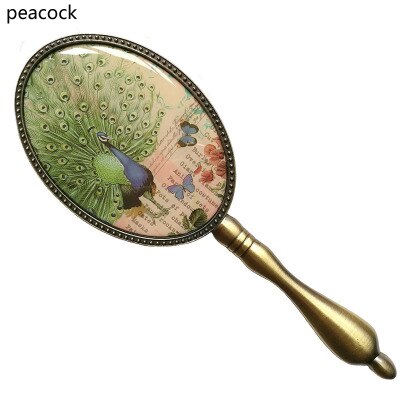 Europeisk vintage antik mässing oval 3 x 4 tum metalllegerad inramad glashandspegel med fjäril epoxidekor bak: Påfågel