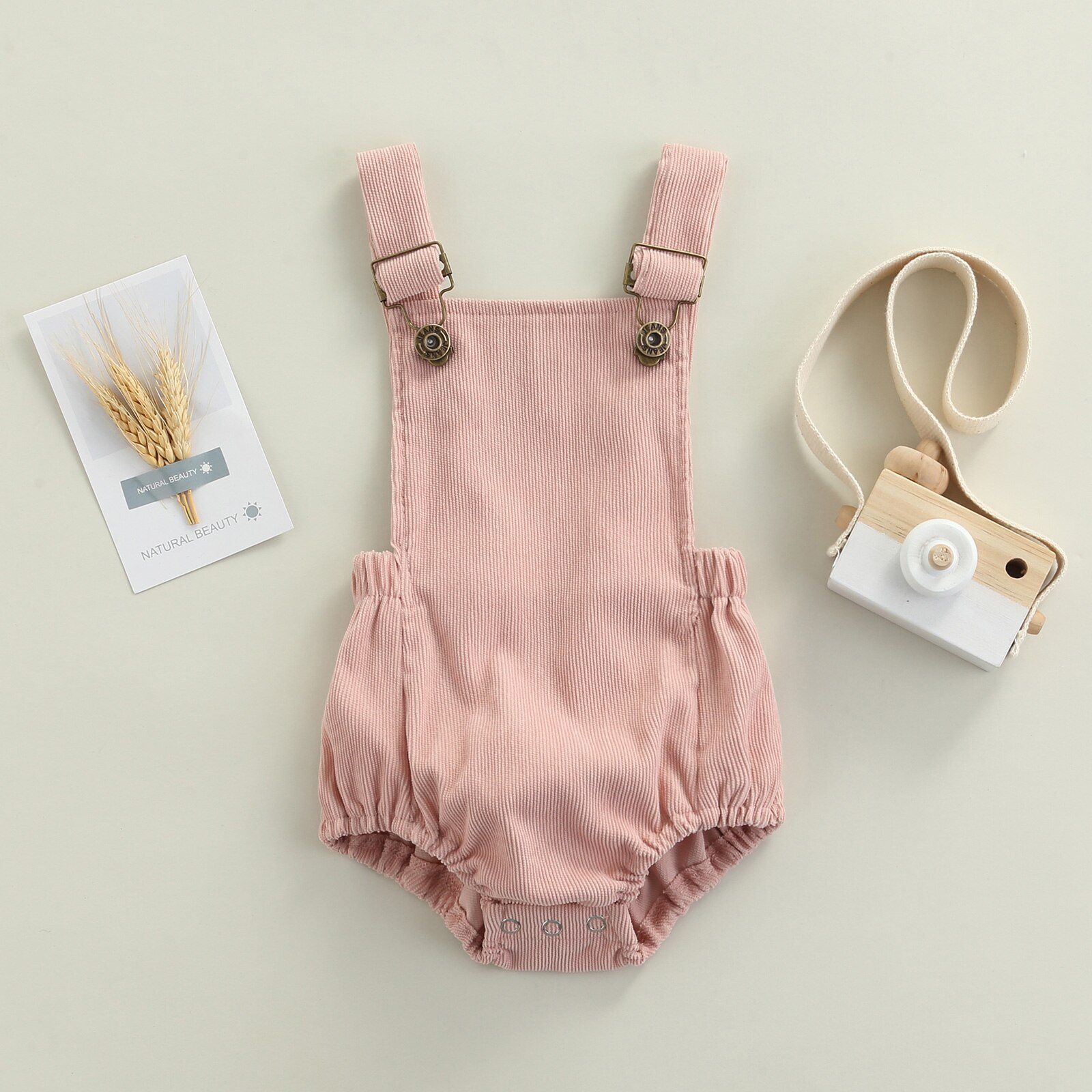 Sommerlicher, lässiger strampler für babys und kleinkinder, einfarbig, eckiger ausschnitt, ärmellos, mit hosenträgern und offenem rücken.