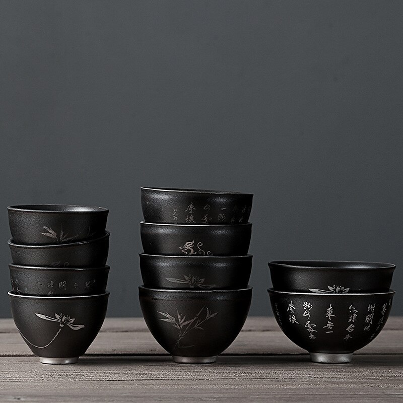 Beschrijving van een zwarte theekop van aardewerk, een zilveren retro theekopje, een zen theekopje, een middelgrote theeset met een kop en een pin-cha-bei.