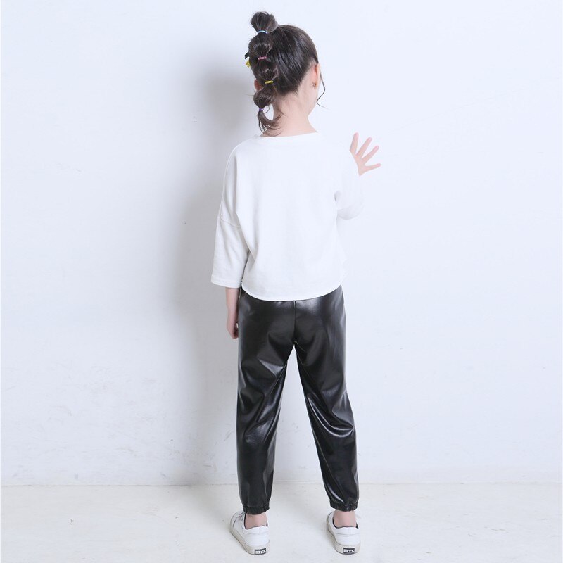 Del bambino del bambino del bambino del bambino della ragazza black stretch in pelle artificiale close-lato di modo allentato pantaloni