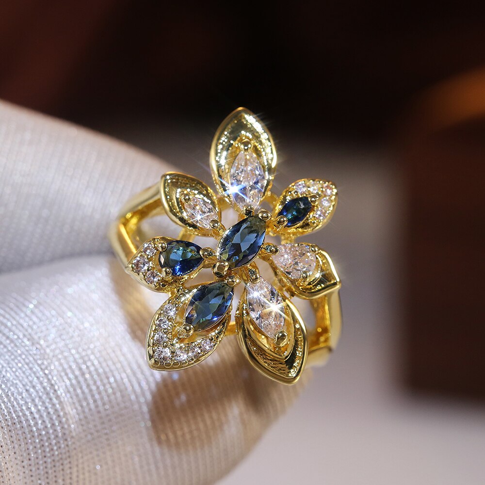 Huitan luksus guldfarve blomst bryllup kvinder ring udhulet dobbelt lag hvid & blå cubic zirconia ædle kvindelige ringe