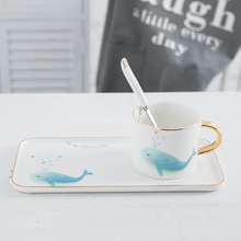 Kort snygg tecknad blåval kaffekopp vacker liten färsk tårta dessert tallrik svart tekopp