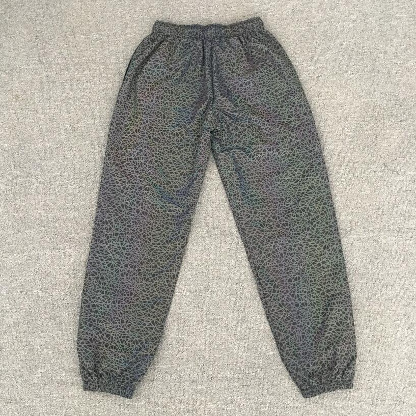 Pantalones Jogger informales luminosos coloridos de hip-hop para hombres europeos y americanos con patrón caótico reflectante