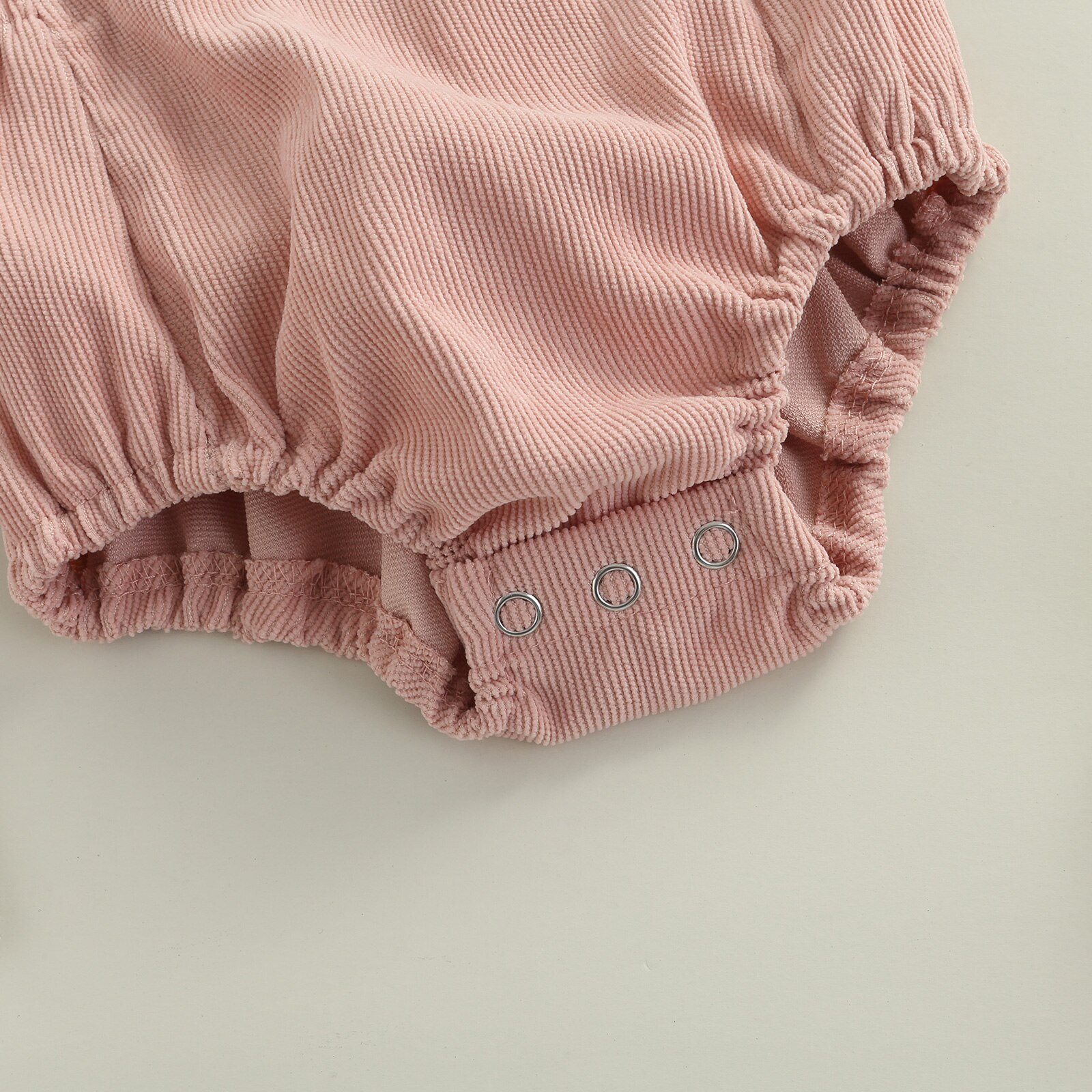 Sommerlicher, lässiger strampler für babys und kleinkinder, einfarbig, eckiger ausschnitt, ärmellos, mit hosenträgern und offenem rücken.