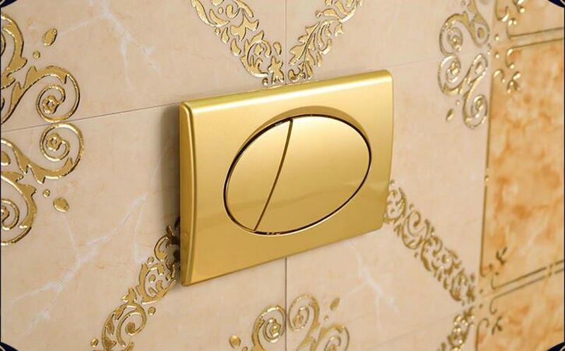 Vægbeslag hånd, der trykker på gyldent toiletskylleknap til væghængt toilet