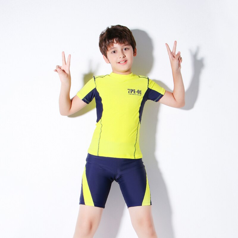 Teenagedrenge bærer to-delt badetøj børnetøjs sportstøj kortærmet gul skjorte og blå shorts