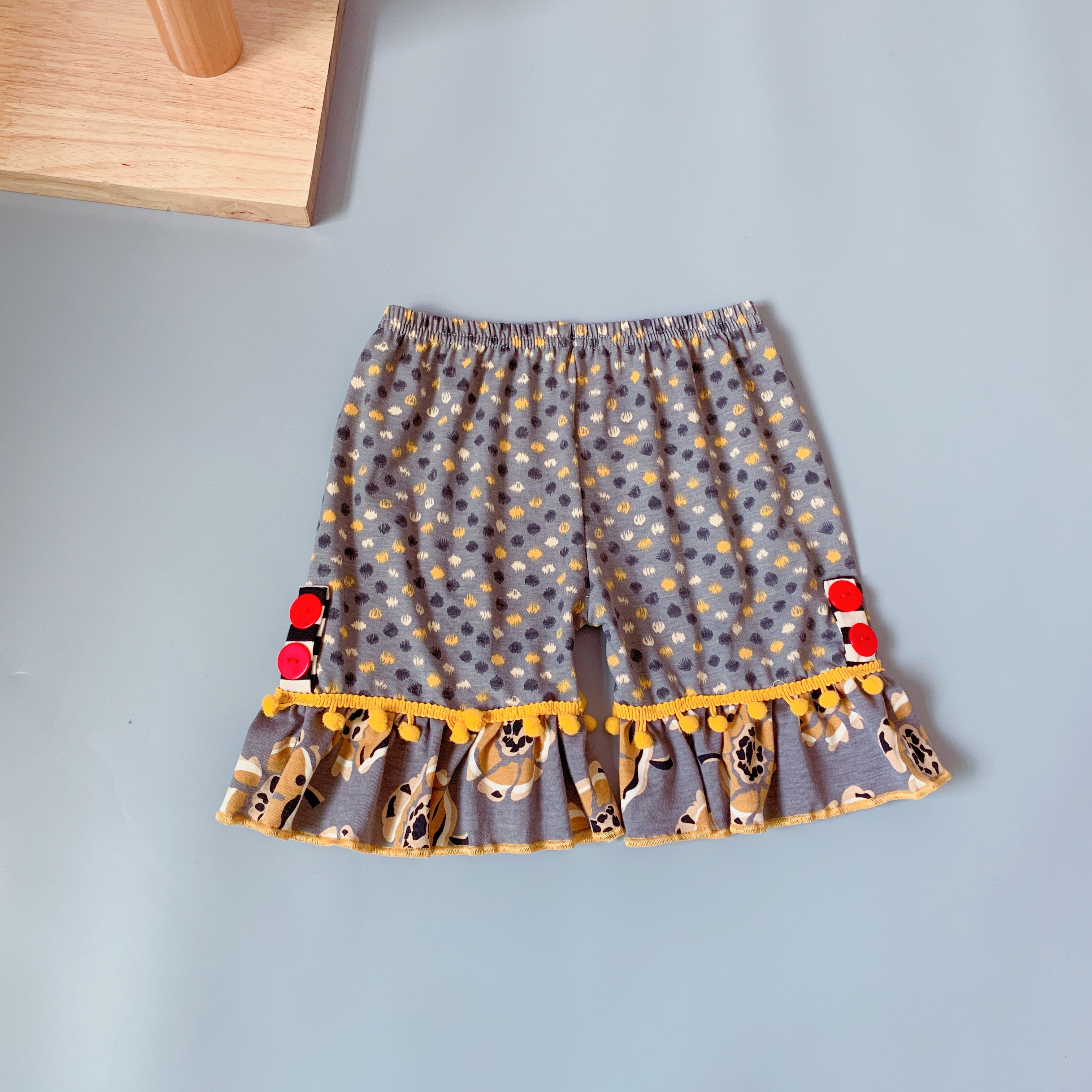 bruin polka dot patroon gedrukt shorts meisje vlakte broek zijn plisse met geel kwastje en rode knop zwart broek