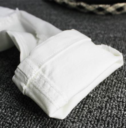 Jeans barnpojke vita avslappnade byxor i den stora pojken vår och höst smala fötter trasiga byxor bokstäver broderi