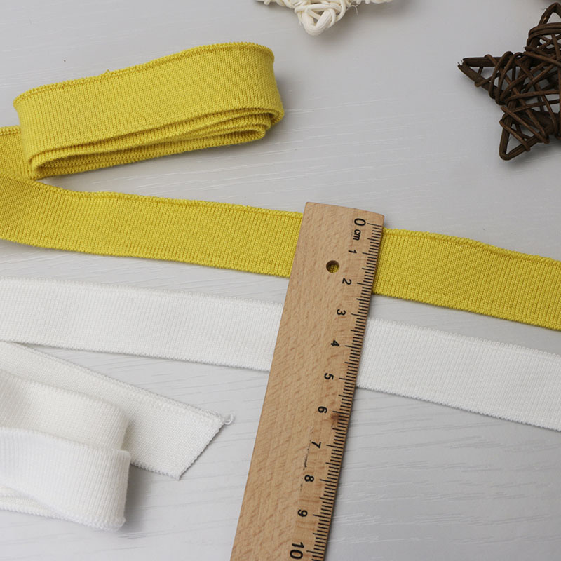 2cm brede, ensfargede, myke, ribbede t-hals i mercerisert bomull, korte mansjetter, elastisk, trådet kant