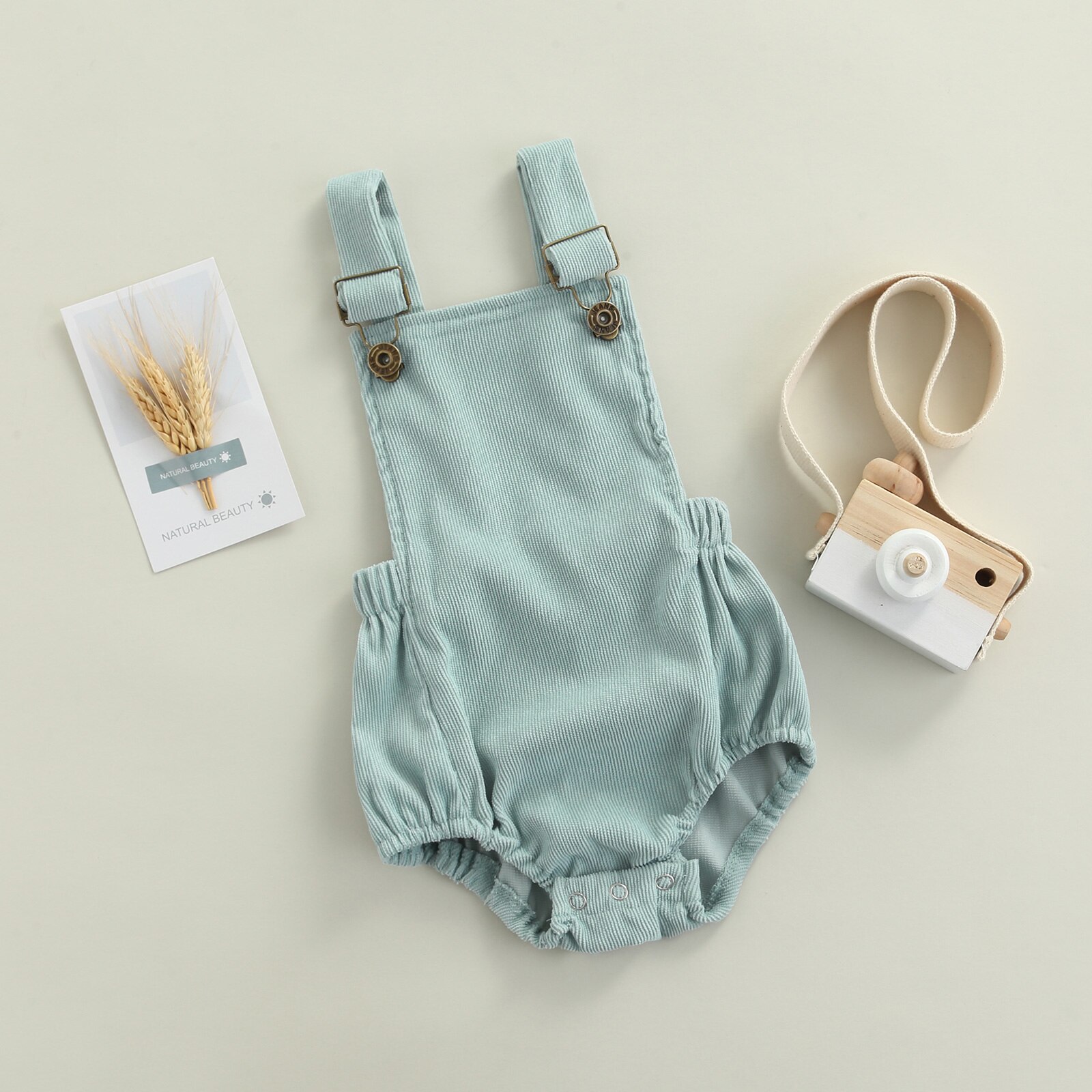 Sommerlicher, lässiger strampler für babys und kleinkinder, einfarbig, eckiger ausschnitt, ärmellos, mit hosenträgern und offenem rücken.