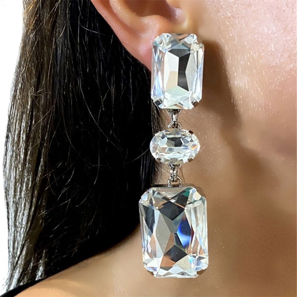 Prachtige, glanzende oorbellen met grote strass-steentjes, perfect als bruids- of feestsieraad.